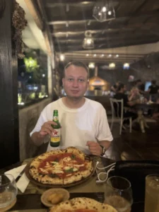 Berkay Having Italian Pizza and Bintang Beer at Restaurant